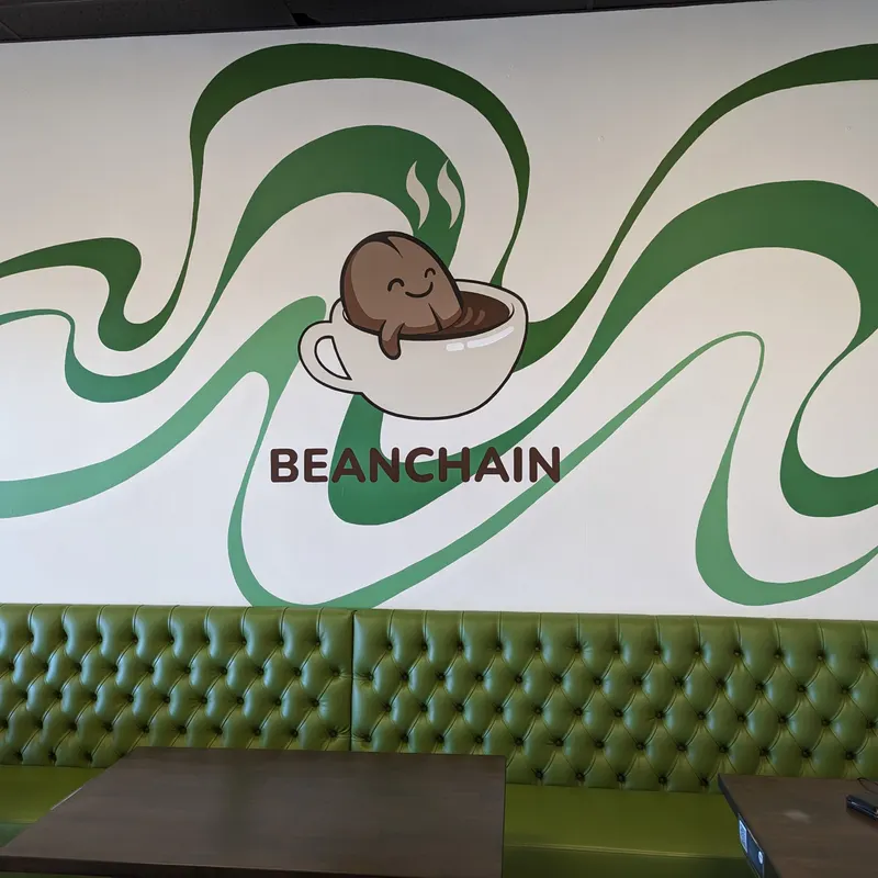 The green ribbon mural on the wall inside the shop, above a green banquette.