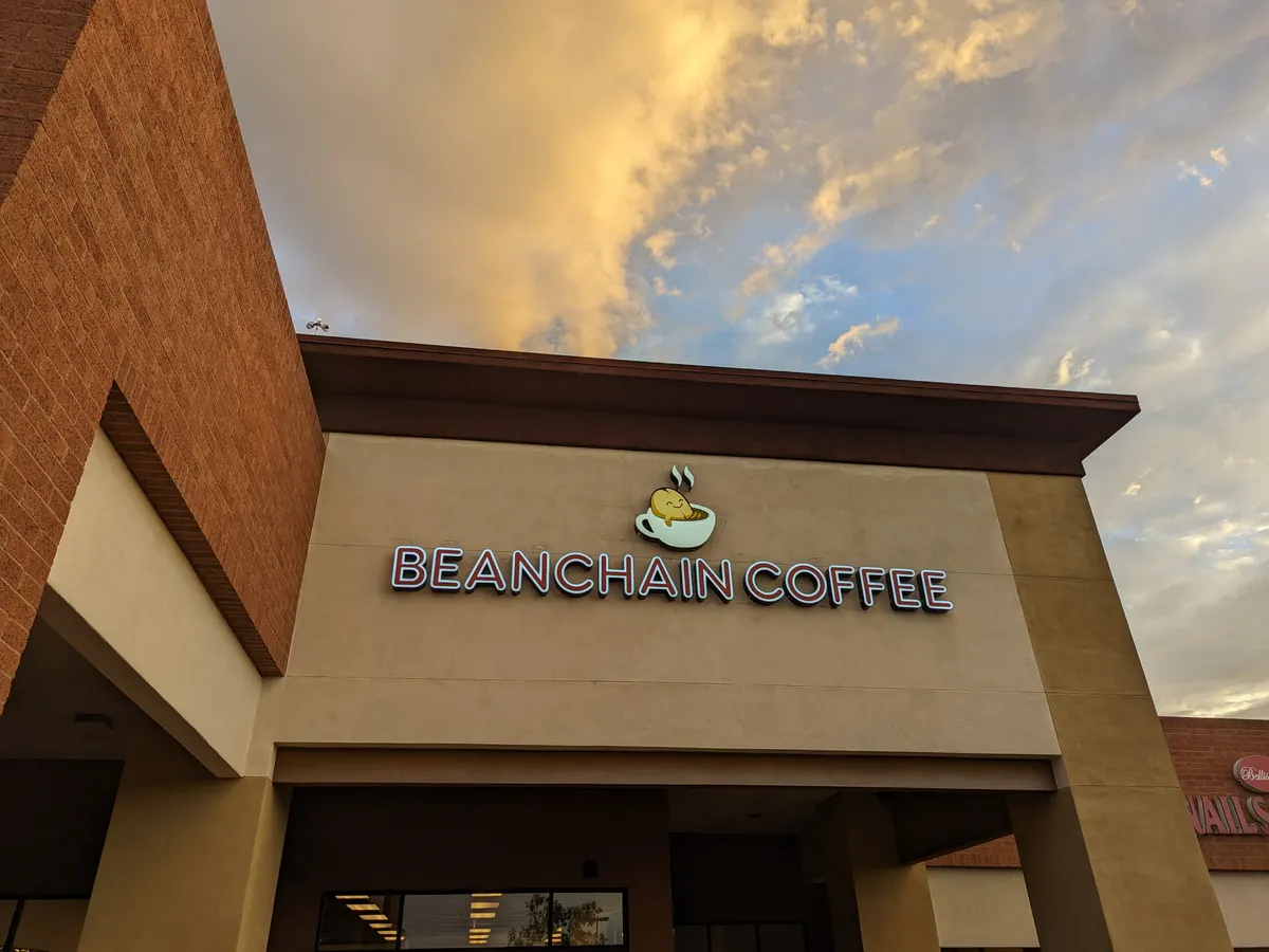 The Beanchain Coffee sign on the front of the building under a gold and blue evening sky.