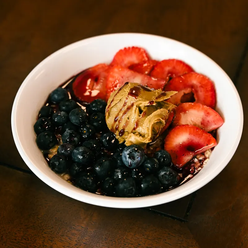 Day Oats in a bowl, topped with strawberries and blueberries.