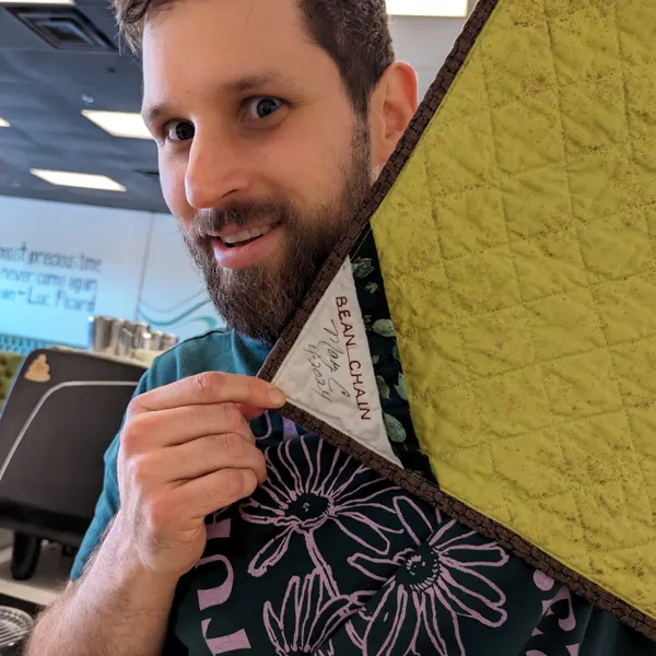A community quilt made by customers, hanging in the shop.